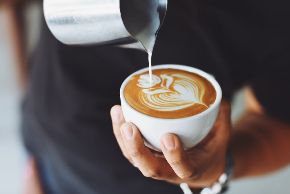 man pouring cappuccino