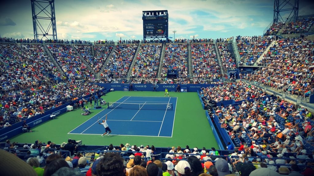 tennis match in an arena with large crowd