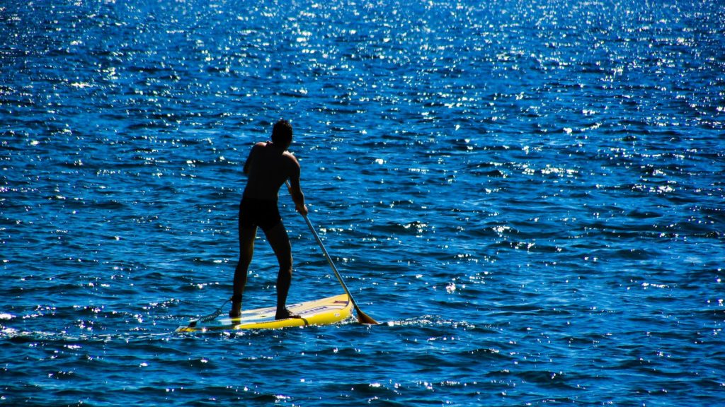 guy stand up paddle boarding on the ocean