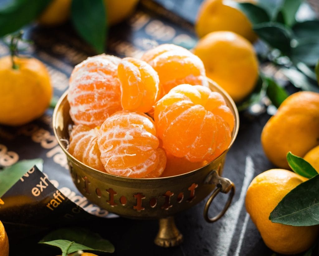 peeled clementines in a metal bowl