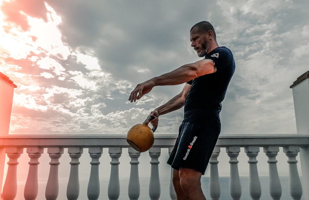 man outside working out with kettle bell