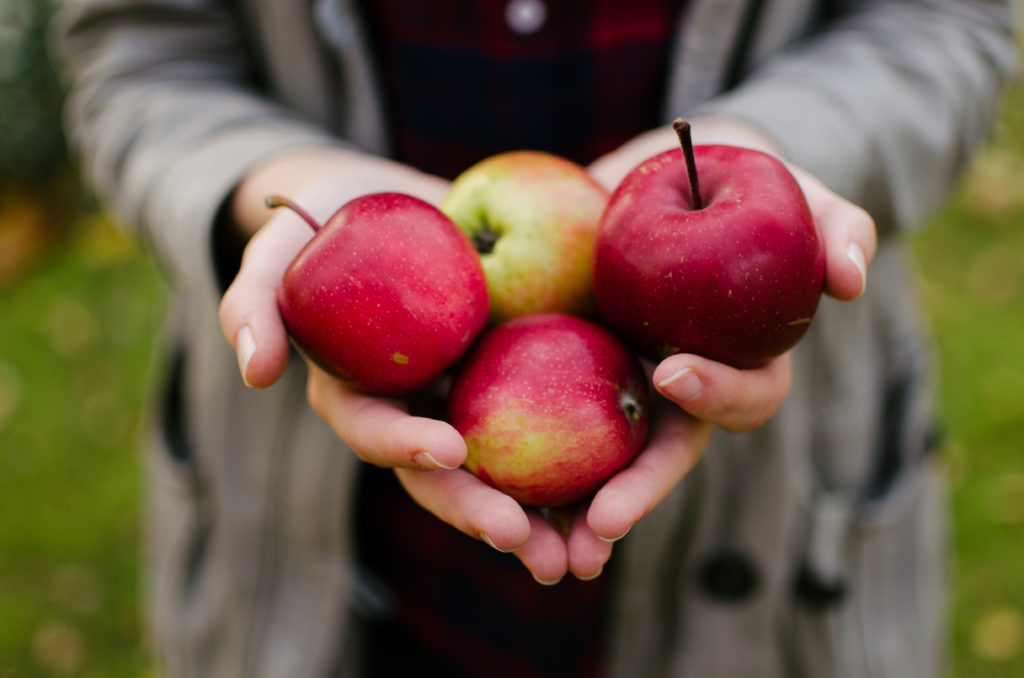 four red apples in women's hand
