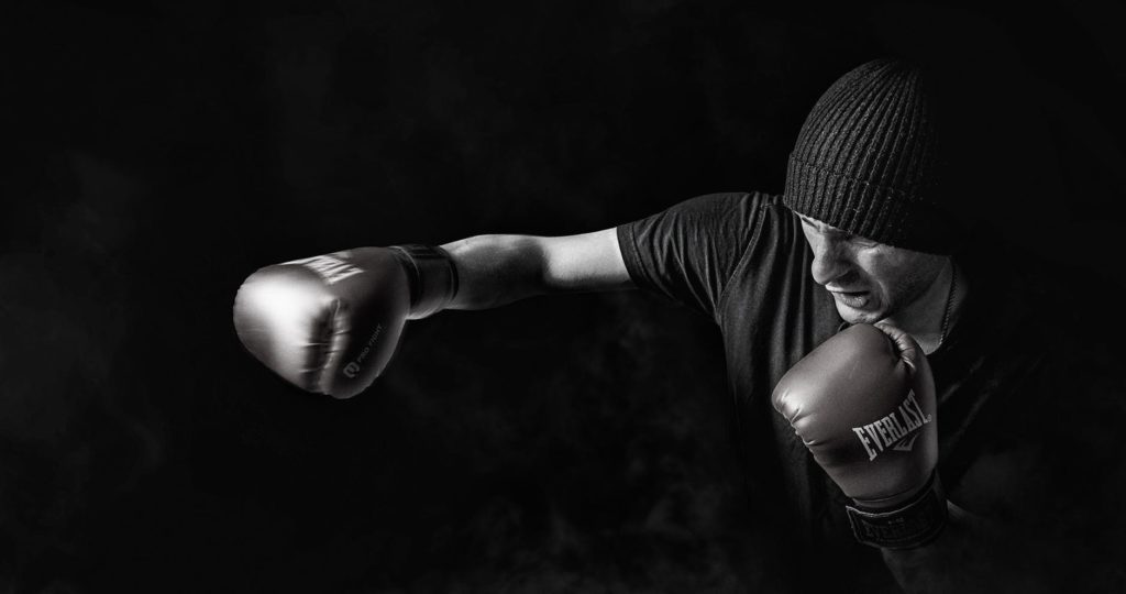 white man in beanie and shirt boxing, black and white