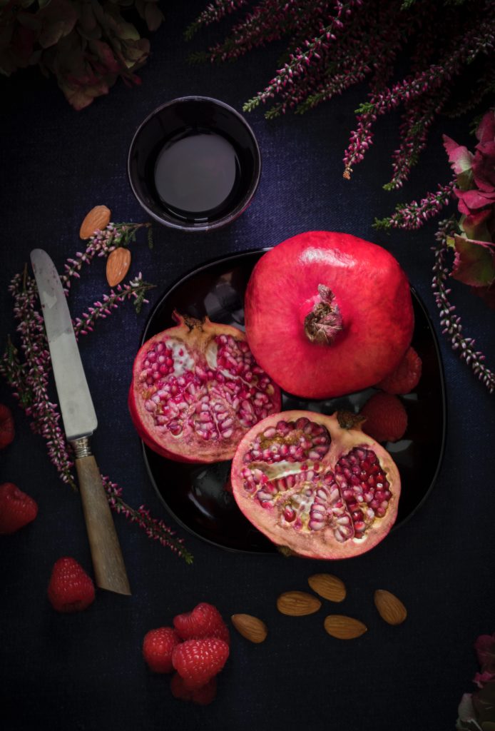 pomegranate cut open with knife next to it