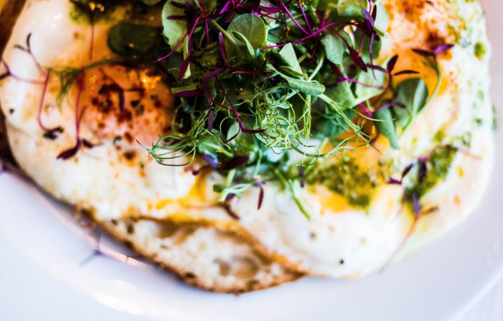 fried eggs with microgreens on top, breakfast food