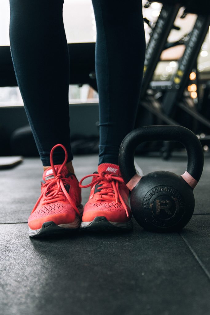 kettlebell sitting next to pink sneakers