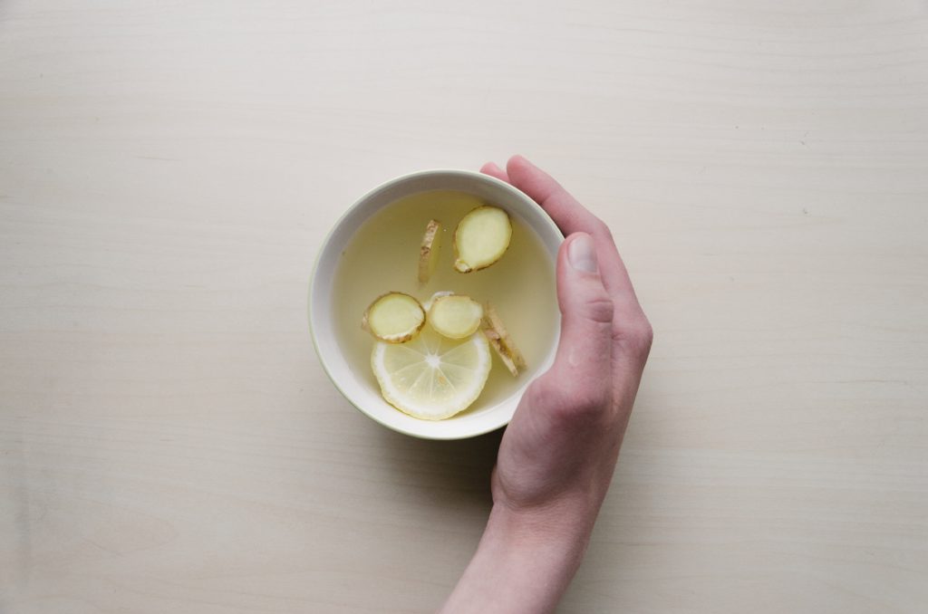 tea with lemon and ginger and female hand