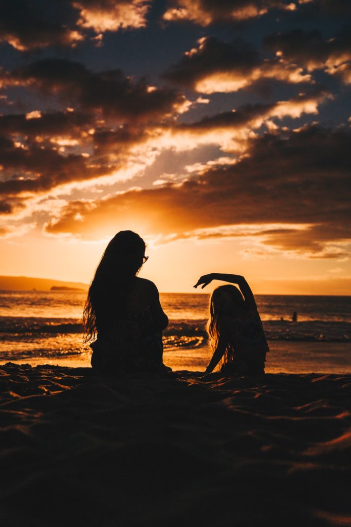 mother and daughter on the beach at sunset