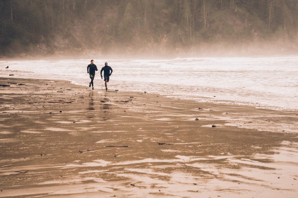 two men running on the beach