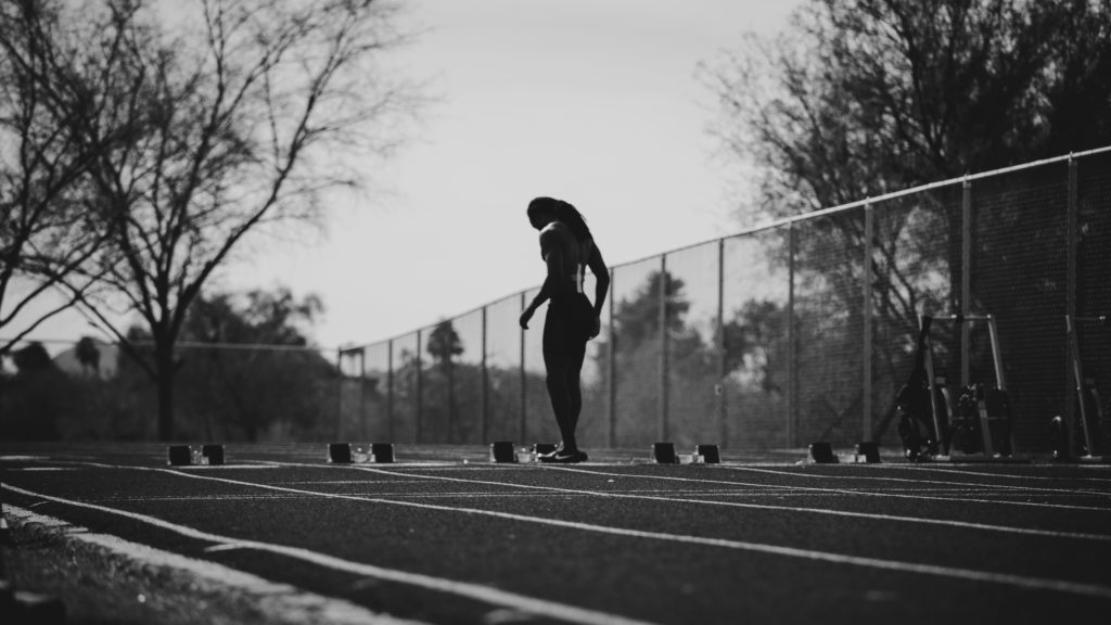 female sprinter at track, black and white