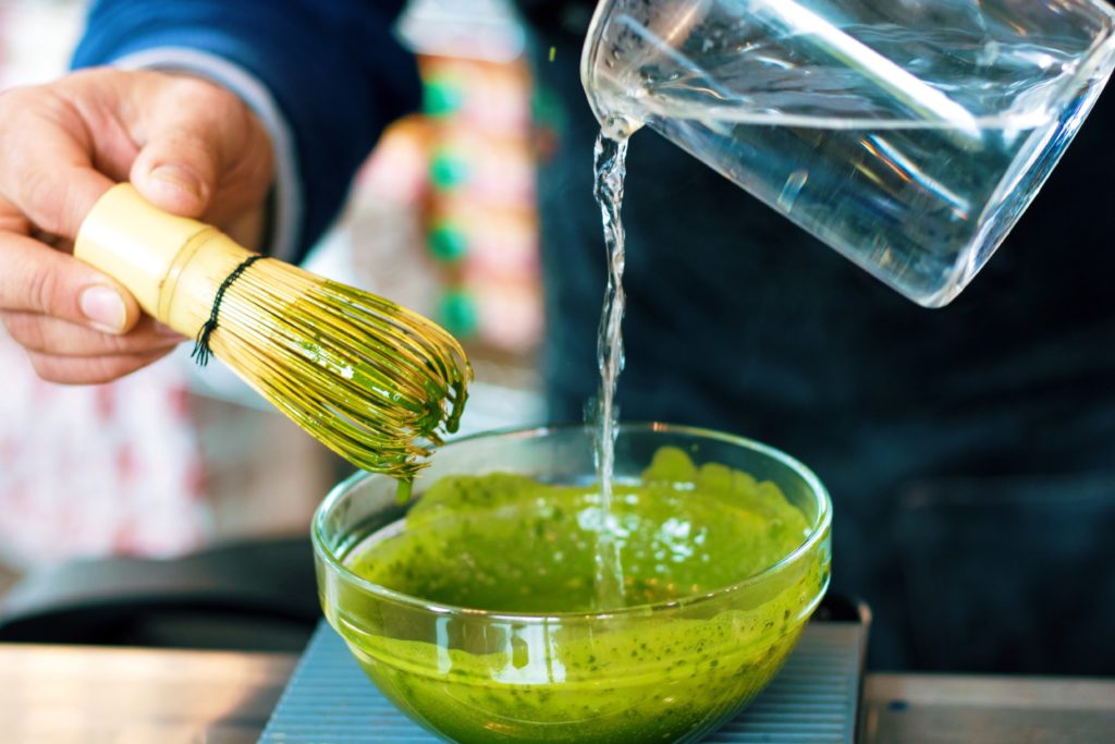 water pouring over matcha powder