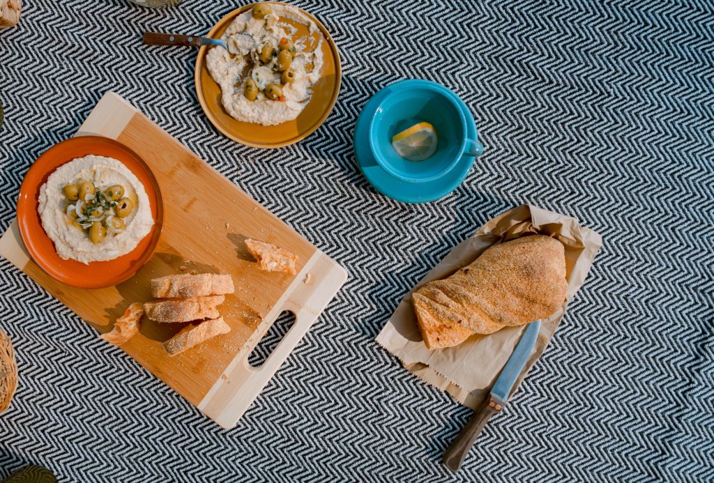 hummus and bread on a cutting board