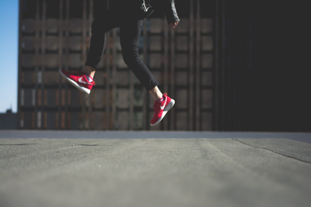 person jumping with red nikes