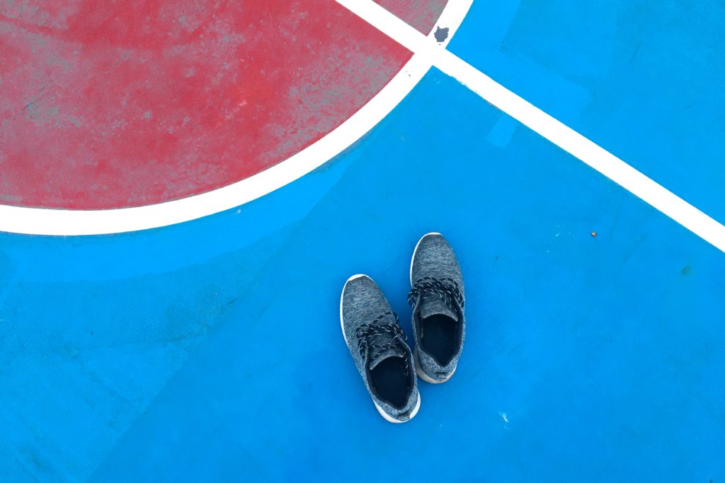 pair of sneakers on a blue and red court