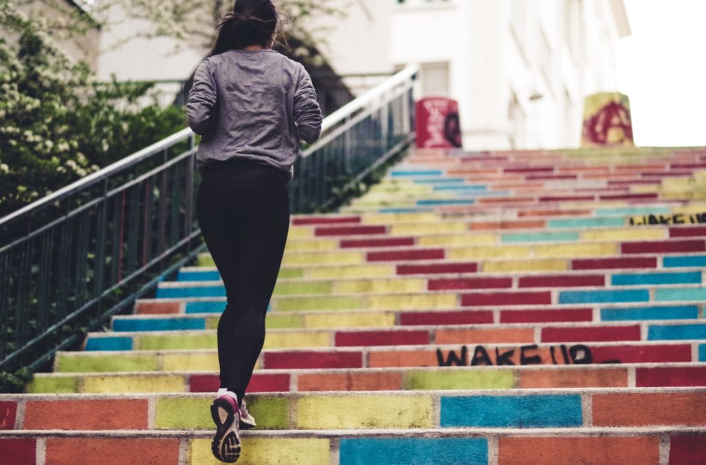 women running up colorful stairs