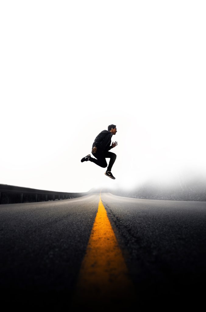 man jumping in the middle of the road