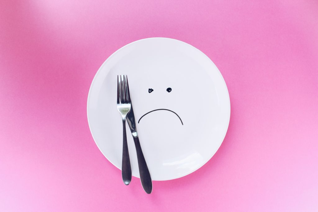 plate with a sad face and fork and knife
