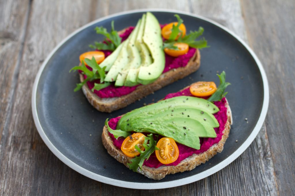 open faced sandwich with avocado and beet hummus
