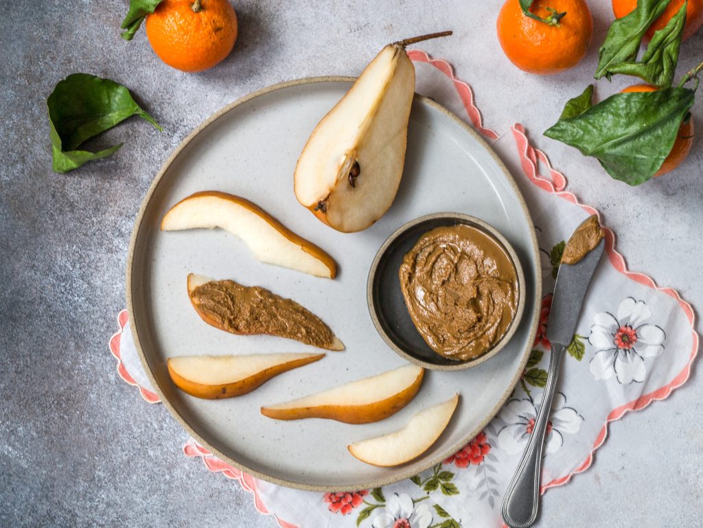 peanut butter and sliced up pears on a plate