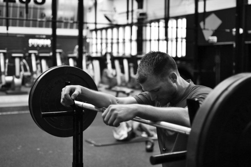 man resting on a barbell